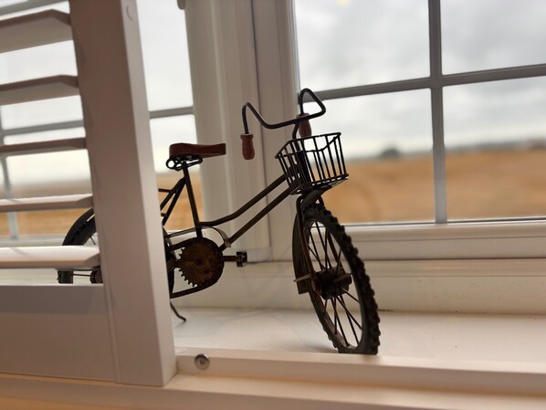 Una bicicleta con una cesta sobre un alféizar blanco.