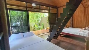 A room with two beds, a staircase, and a large window overlooking greenery. - Your Tagaytay Escape Here in Mendez, Where Nature, Relaxation, and Fun Await (Mendez)