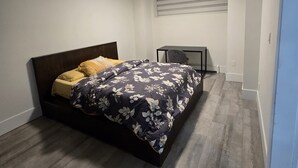 A bedroom with a bed, a desk, and a window with blinds. - Spacious private  suite in  Surreywith laundry,workspace,internet and parking (Surrey)