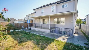 A two-story house with a covered patio, a fenced backyard, and a front yard. - Spacious private  suite in  Surreywith laundry,workspace,internet and parking (Surrey)