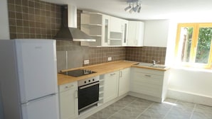 A compact kitchen with white cabinets, a built-in oven, a stove, and a refrigerator. - Loft Bonziers - authentic alpine experience (6p, sauna) (Peisey-Nancroix)