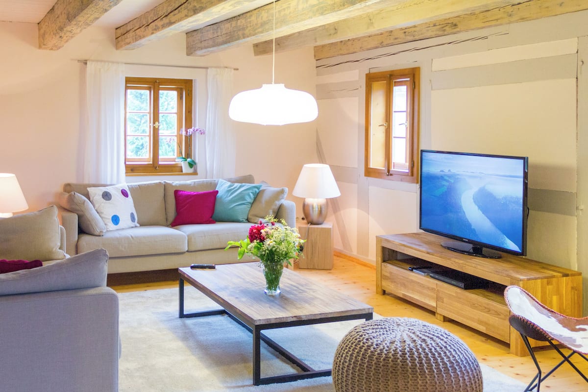 Un salón acogedor con sofá, sillón, mesa de centro y televisor.