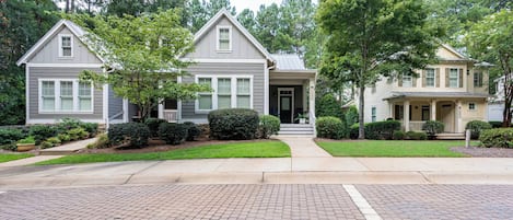 A two-story house with a front porch, a driveway, and a well-maintained lawn.
