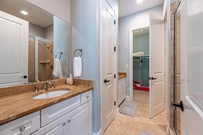 Une salle de bain moderne avec un lavabo, un miroir et une douche.