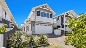 A modern two-story residential building with a white exterior, a covered porch, and a garage. - The Palms on Nautilus (Kingscliff)