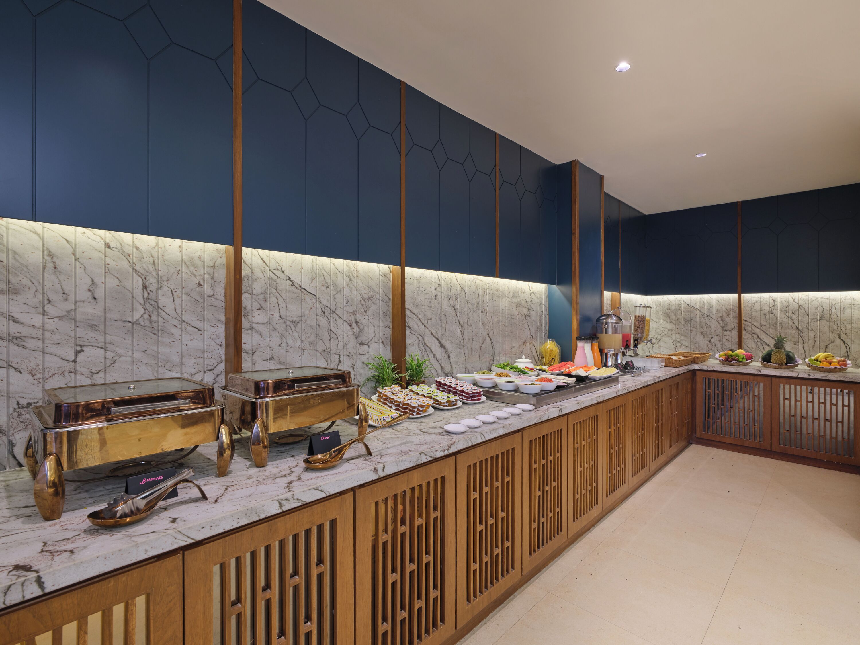 A buffet setup with various food items and a marble countertop.