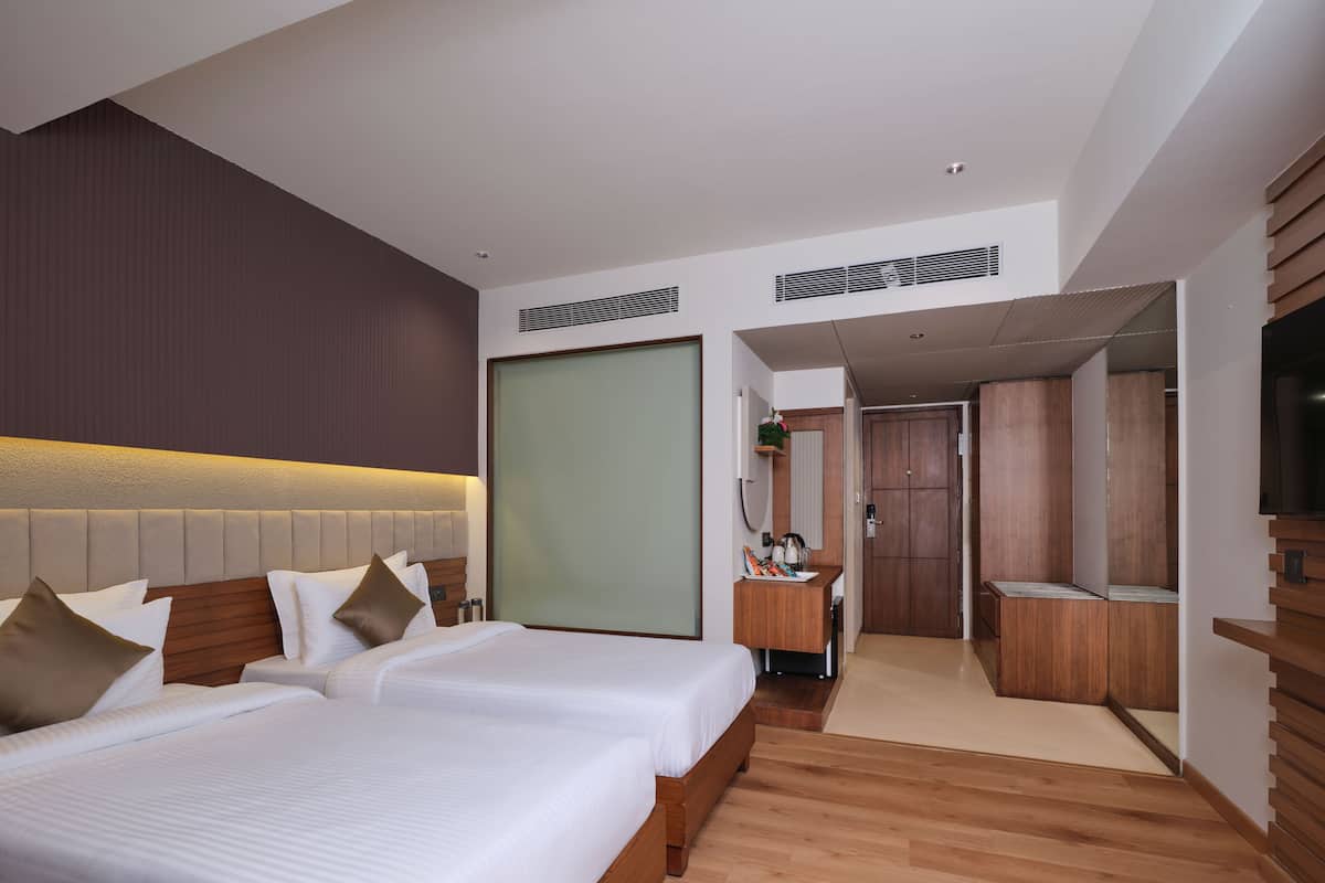 A modern hotel room with a large bed, a desk, and a walk-in closet.