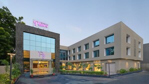 A modern hotel with a prominent 'Place' sign, a glass facade, and a well-lit entrance. - Regenta Place Ahmedabad (Ahmedabad)