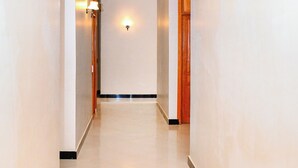 A clean, well-lit hallway with a polished floor, leading to a door at the end. - KER HOTEL DODOMA (Dodoma)