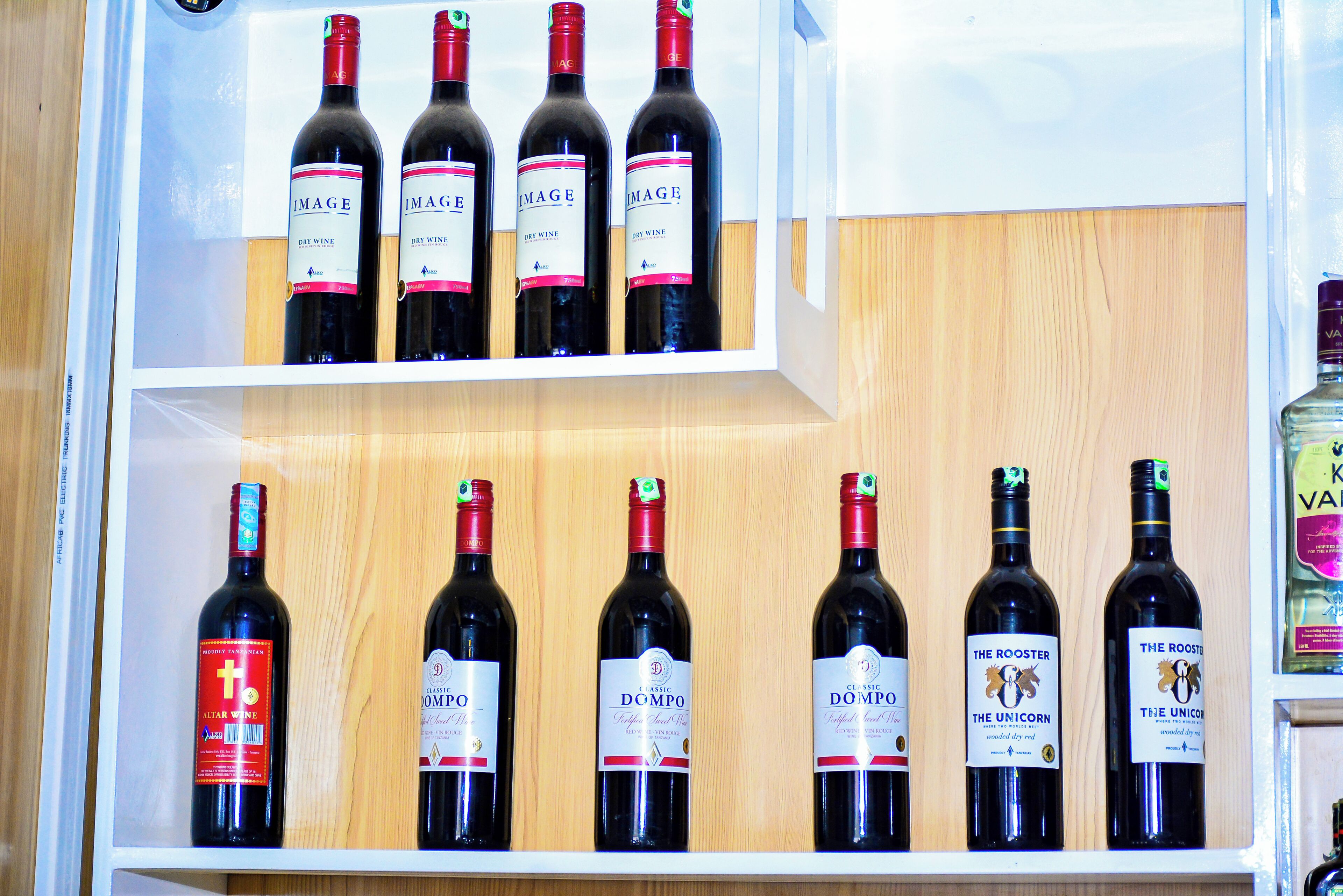 A wine rack with multiple bottles of wine, including brands like 'IMAGE' and 'DOMPO'.
