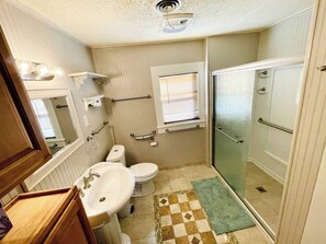 Une petite salle de bain comprenant un lavabo, des toilettes et une douche.
