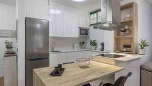 Eine moderne Küche mit einem Edelstahlkühlschrank, einer Mikrowelle und einem Holzespeisesatz mit Stühlen.