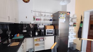 A modern kitchen with white cabinets, a stainless steel refrigerator, a microwave, and a coffee maker. - Quiet vacation apartment near Cologne: Hürth, centrally located (Hürth)