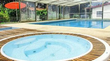 Een seizoensgebonden buitenzwembad en parasols bij het zwembad