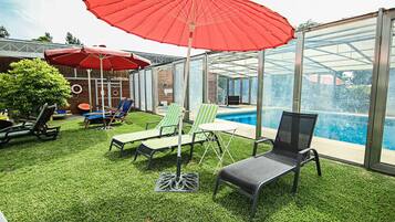 Una piscina al aire libre de temporada, sombrillas