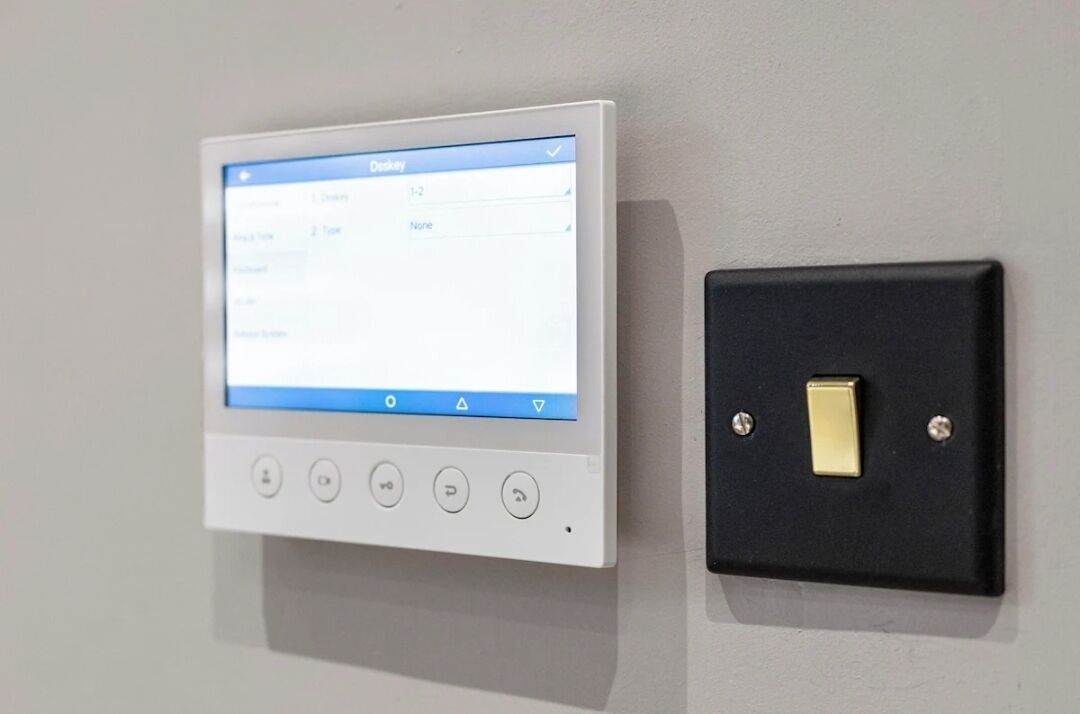 A control panel with a screen and buttons, and a wall-mounted switch.