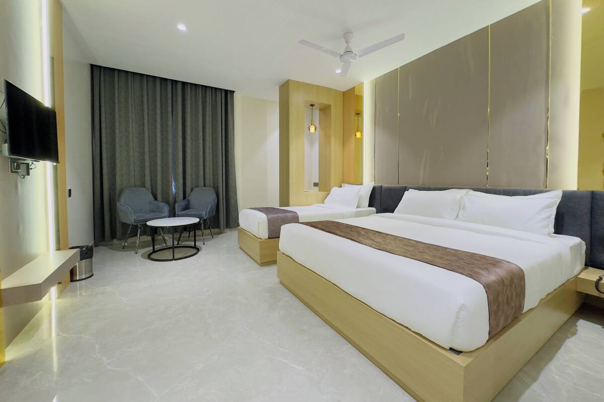Une chambre d’hôtel moderne équipée d’un grand lit, d’un bureau, d’une chaise et d’un téléviseur.