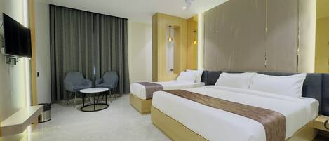 A modern hotel room with a large bed, a desk, a chair, and a television.