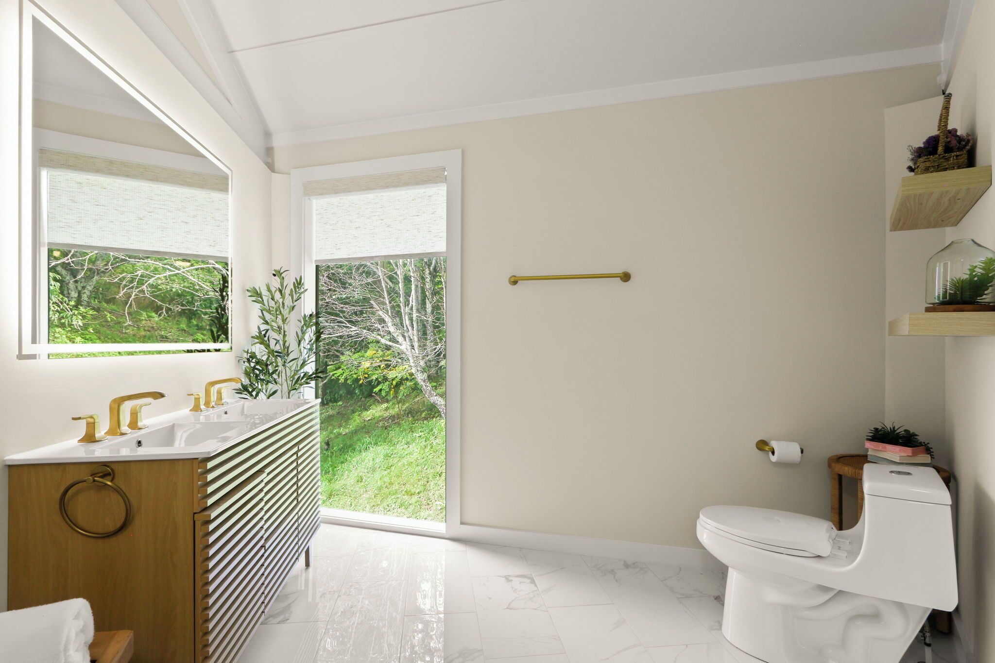 A modern bathroom with a large window, a white toilet, and a wooden vanity.