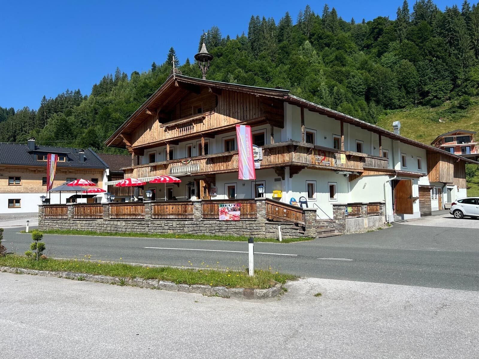 Un immeuble en bois à plusieurs étages, doté de balcons, d’une base en pierre et d’un drapeau.