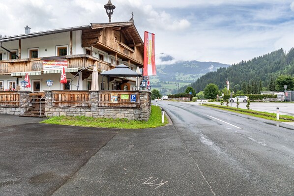 A traditional wooden building with a balcony, a signboard, and a flag.