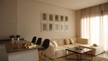 A modern living room with a sofa, chairs, a coffee table, and artwork on the wall.