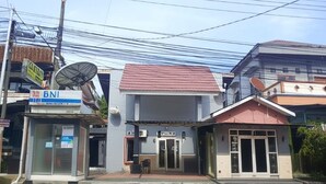 A building with a red roof, a satellite dish, and a sign for BNI.
