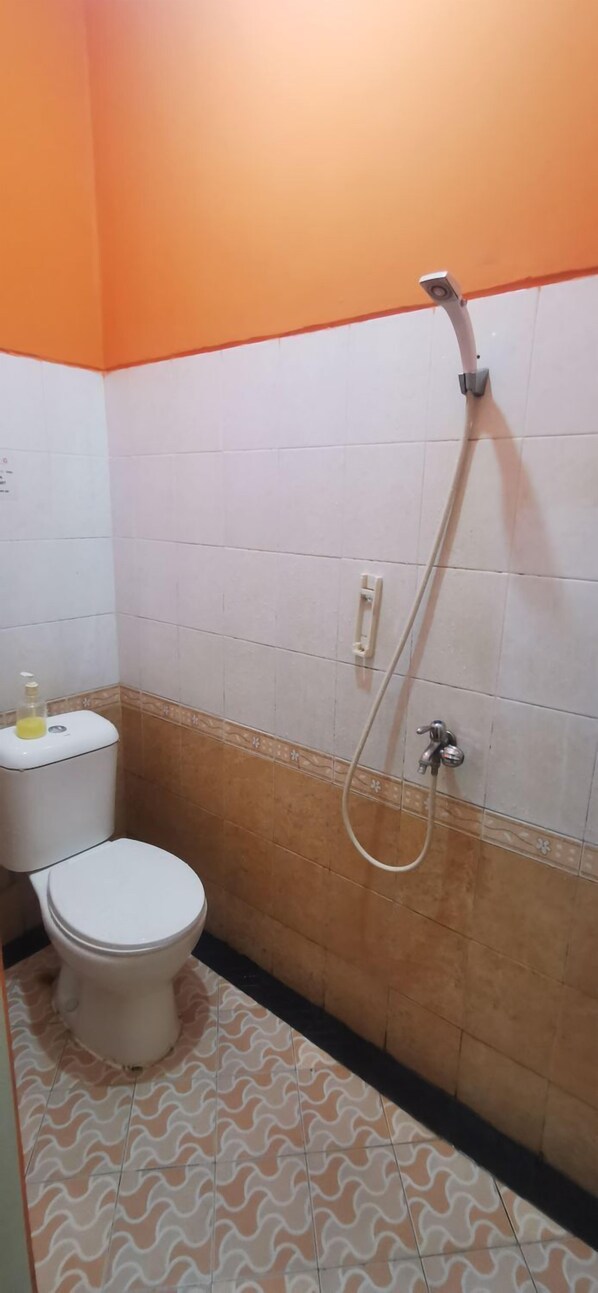 A bathroom with a toilet, a shower, and a patterned floor.