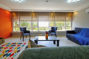 Condo Deluxe, 1 cama Queen size y sofá cama, cocina, vista al mar | Área de sala de estar | Smart TV de 43 pulgadas con canales por cable