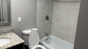 A bathroom with a toilet, sink, and shower. - Fieldstone Apartments & Studios  (Fairmont)