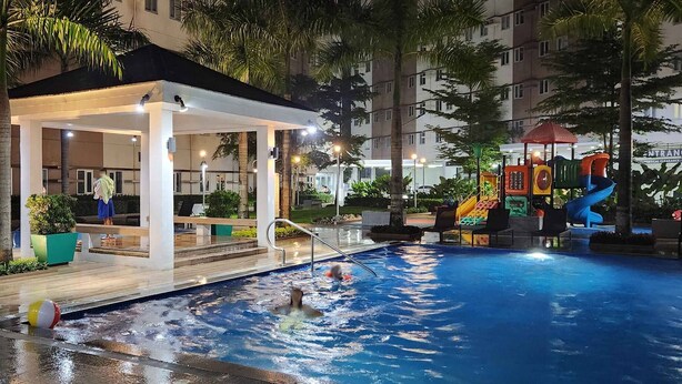 A swimming pool area with a covered seating area, water slides, and a lifebuoy. - Colin's Suite at Hope Residences (Trece Martires)