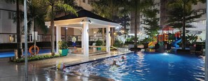 A swimming pool area with a covered seating area, water slides, and a lifebuoy. - Colin's Suite at Hope Residences (Trece Martires)