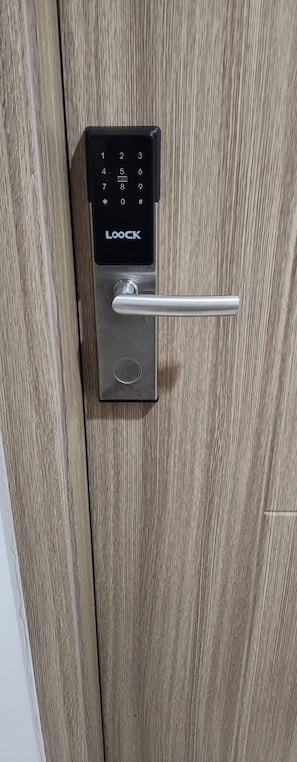 A modern door with a digital lock and a keyhole. - Colin's Suite at Hope Residences (Trece Martires)