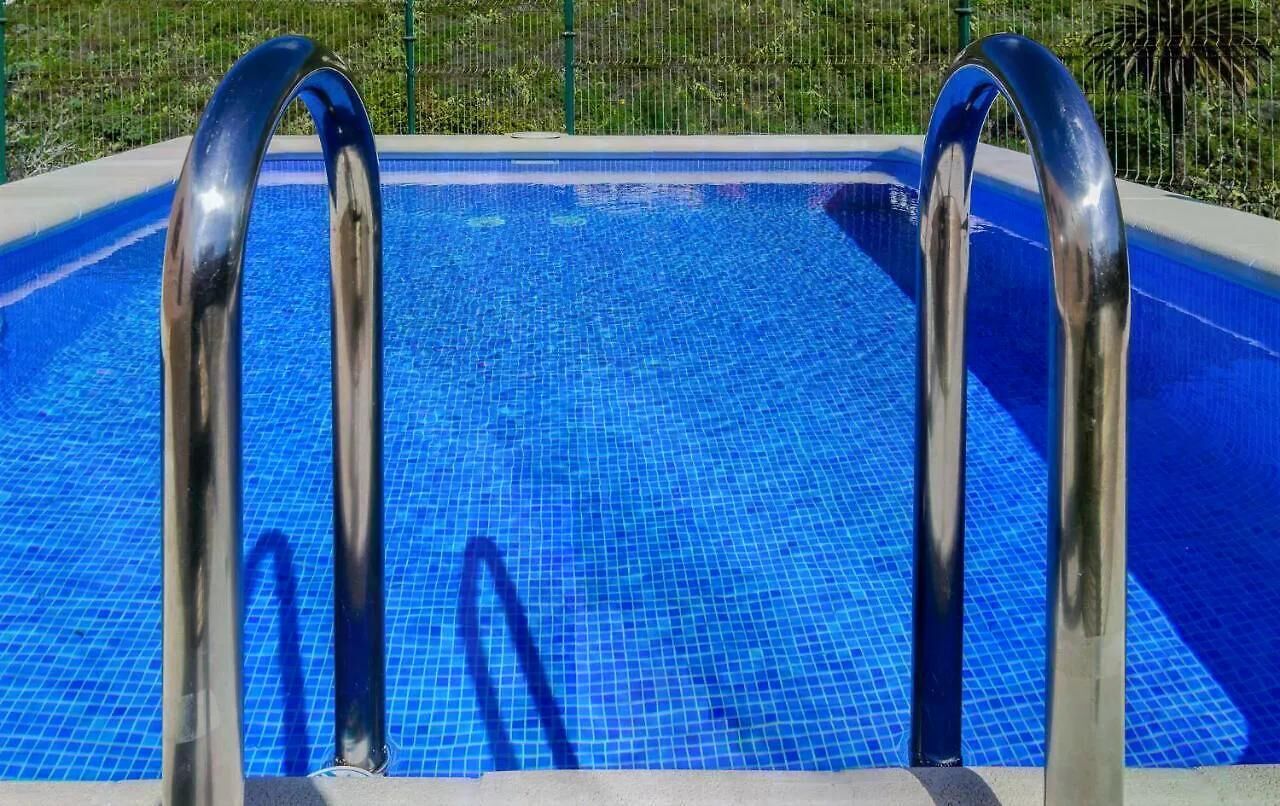 A swimming pool with metal handrails and a tiled floor.