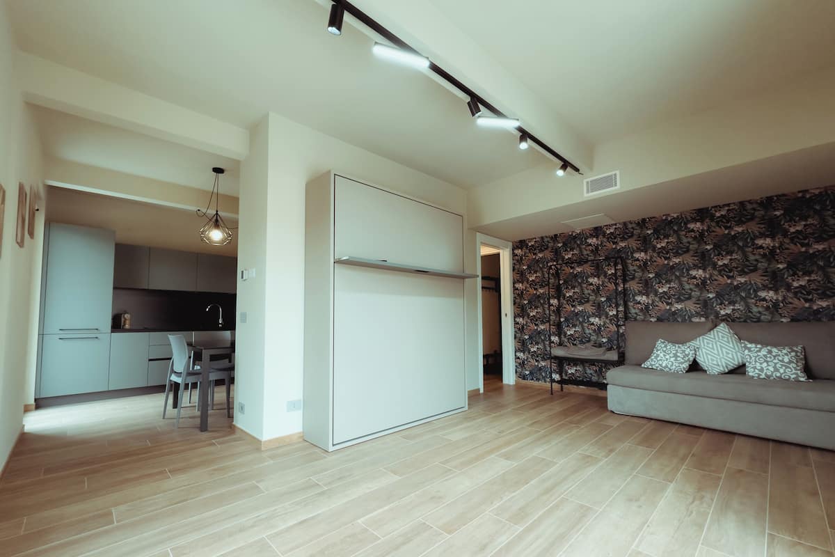 A modern living space with a kitchen, dining area, and a sofa.