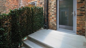 A brick building with a metal staircase leading to a door.