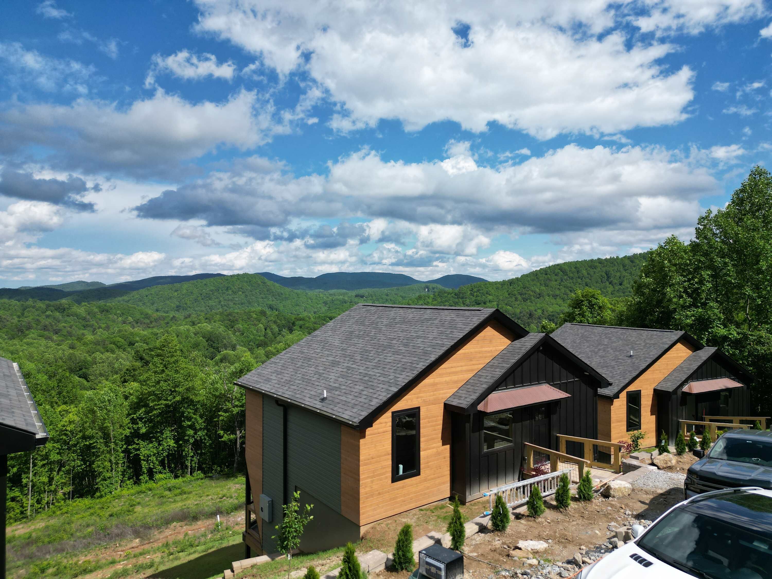 A row of cabins with a view of a forested mountain range.