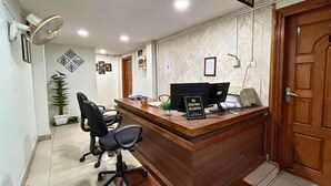 A reception area with a wooden desk, a computer, and a sign indicating no visitors allowed. - YSM Grand  (Guwahati)