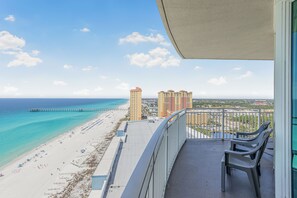 A balcony with a view of a beach, a pier, and high-rise buildings. - 19th-Floor Gulf-Front Retreat at Aqua Resort | w/ 2 Sets of Beach Chairs (Panama City Beach)