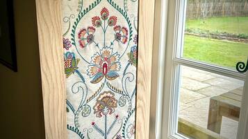 Una ventana con marco de madera y un estampado floral.