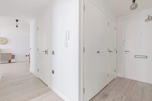 Een moderne hotelkamer met witte muren, een houten vloer en een grote kast.