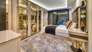 A modern bedroom with a large wardrobe, a bed with a black and white bedspread, and a patterned rug. - Modern 4-bedroom villa • Private pool - 10 min from Kleopatra beach (Antalya)