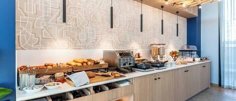 A modern kitchen with a geometric backsplash, built-in appliances, and a variety of breakfast items.