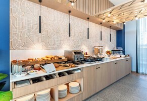 A modern kitchen with a geometric backsplash, built-in appliances, and a variety of breakfast items.