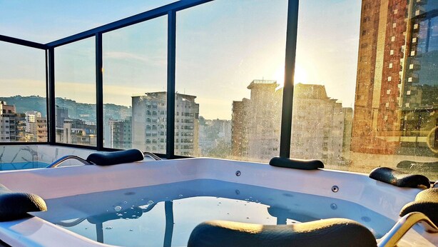Ein Whirlpool mit Blick auf die Stadt durch große Fenster.
