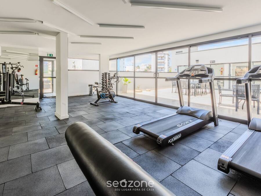 A gym with treadmills, exercise bikes, and weight machines.