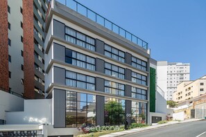 A multi-story building with a modern architectural design, featuring large windows and a flat roof.