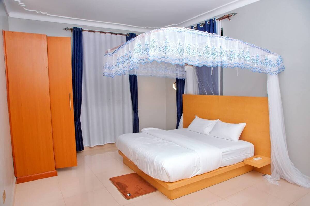 A bedroom with a bed, a wardrobe, and a canopy bed.