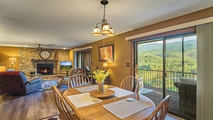 A dining area with a wooden table, chairs, and a fireplace. - Affordable stay with gorgeous views! (Gatlinburg)