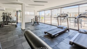 A gym with treadmills, exercise bikes, and weight machines.